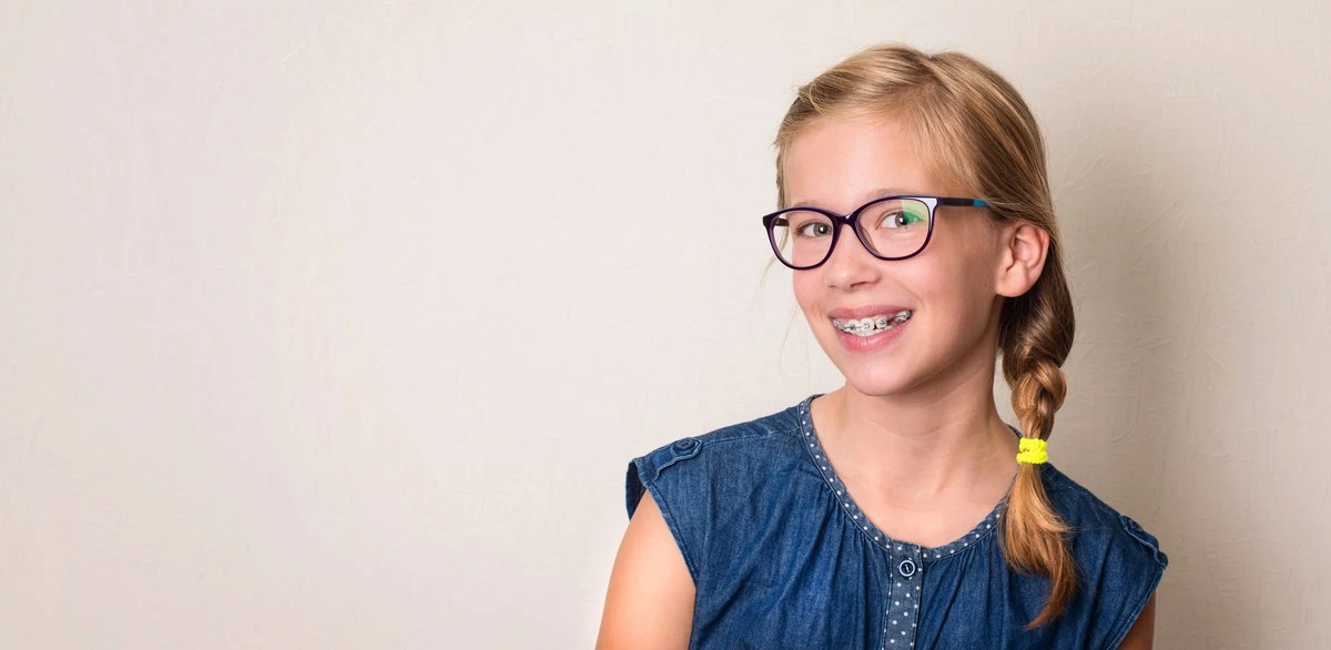 Health, education and people concept. Closeup portrait of happy teen girl in braces and eyeglasses.