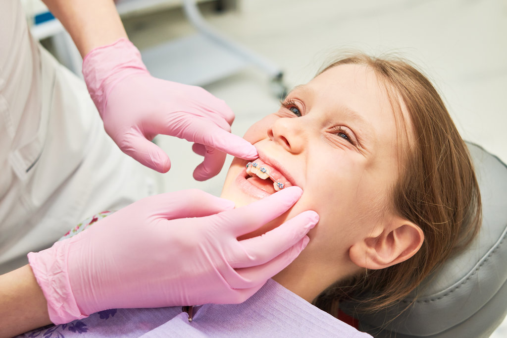 Braces installation and maintenance. Little girl at a dentist's examination.