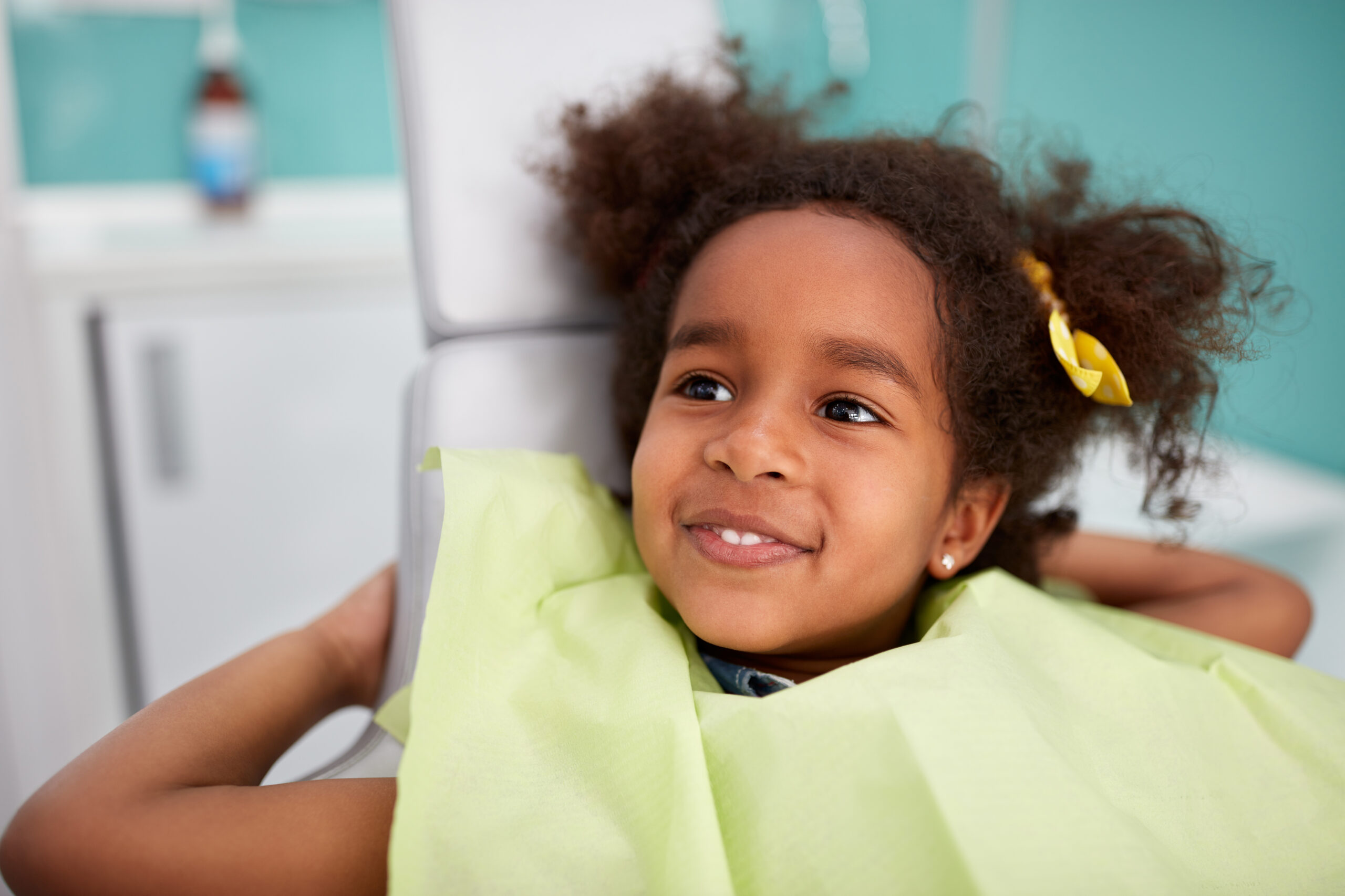 Portrait of satisfied child in dental chair after successful dental treatment