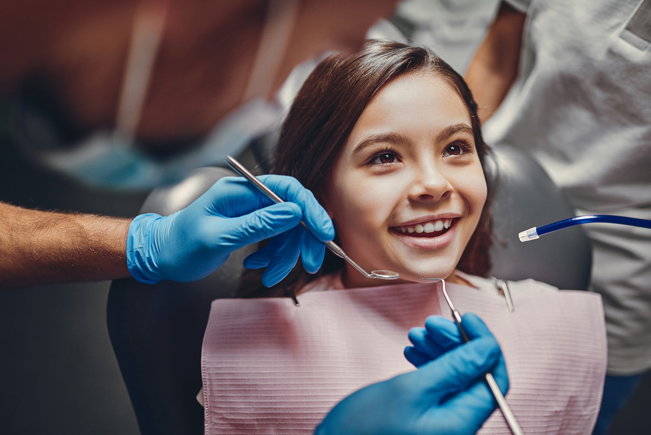 Cute girl in dental clinic. Child in stomatological cabinet with dentists.